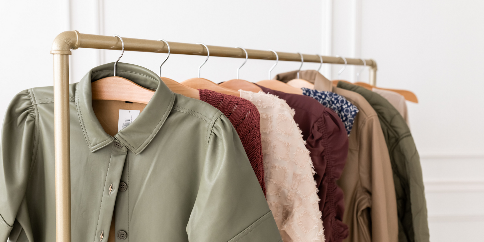 Vegan leather top, ruched sleeve plum blouse, dresses, quilted jacket on clothing rack -  Tru Blue Boutique